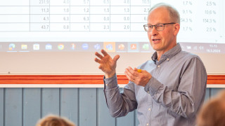Tässä kuvassa henkilö esittelee tutkimustuloksia.