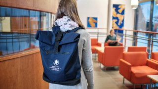 Opiskelija reppu selässä