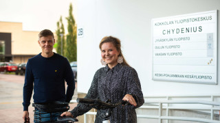 Kaksi opiskelijaa yliopistokeskuksen sisäänkäynnillä